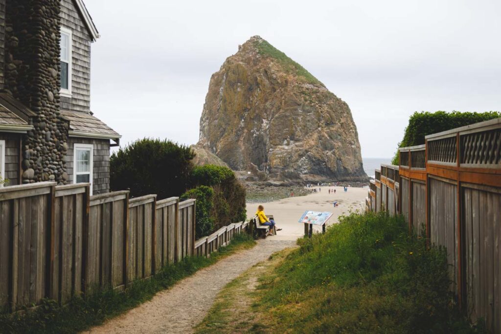 Haystack Rock at Cannon Beach with a sandy path leading the way to the beach.