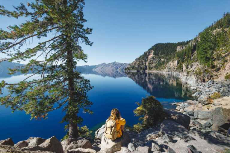 Nina sitting on rocks looking out over Crater Lake.