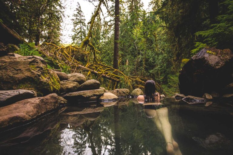 Woman at Cougar Hot Springs overlooking greenery.