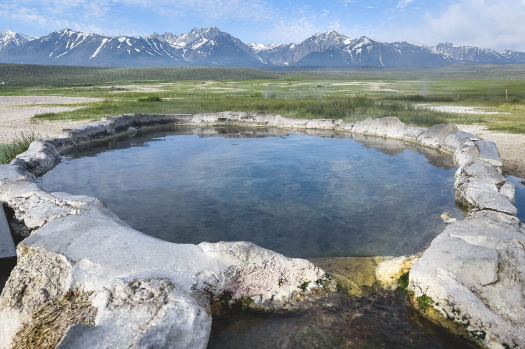 Hilltop Hot Springs - a circular pool with beautiful mountain backdrop.