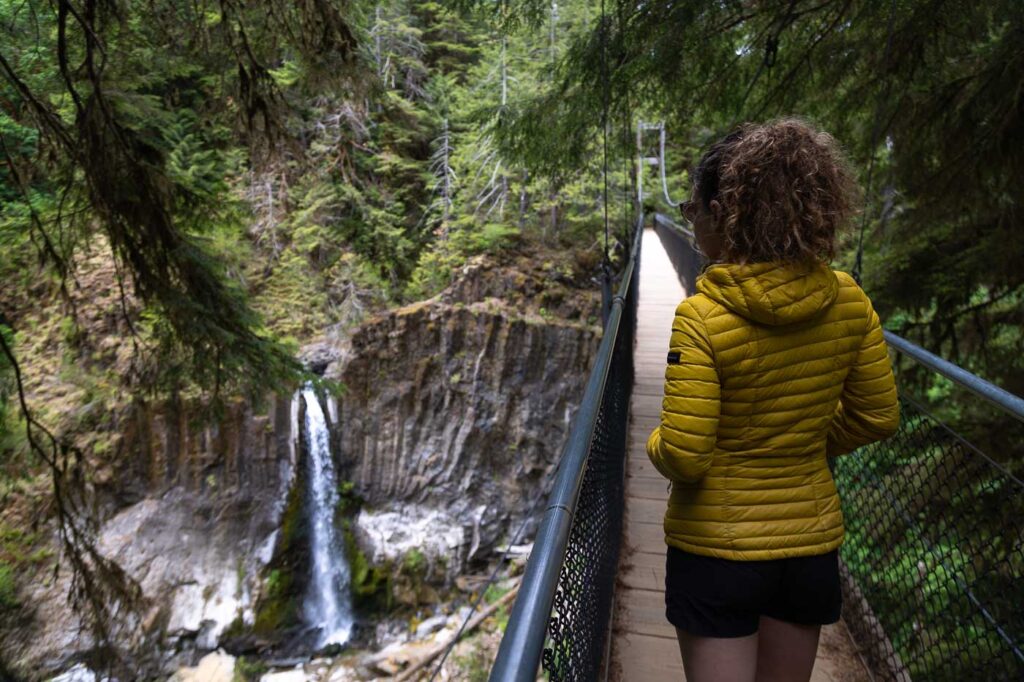 Nina on a bridge with an Oregon Coast waterfall to the left.