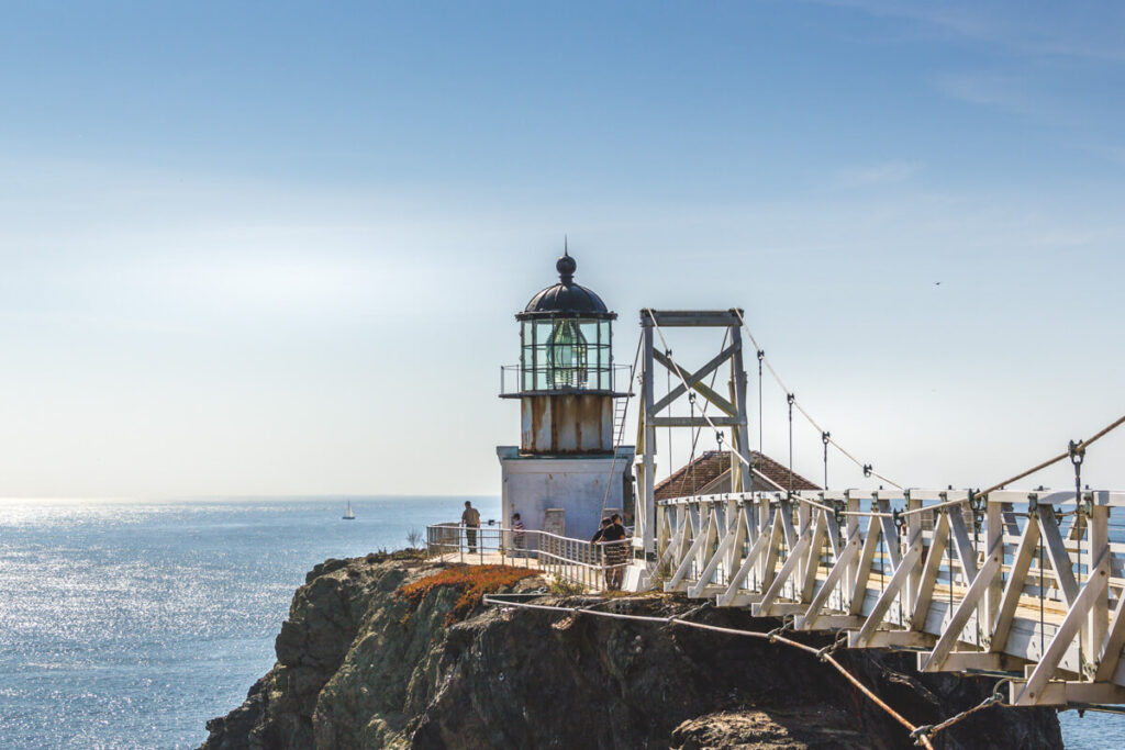 Point Bonita Lighthouse with a bridge leading to it and the sea in the back.