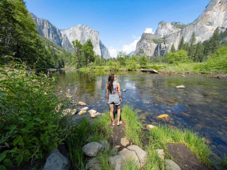 Yosemite Valley with a river running through and Nina standing in front.