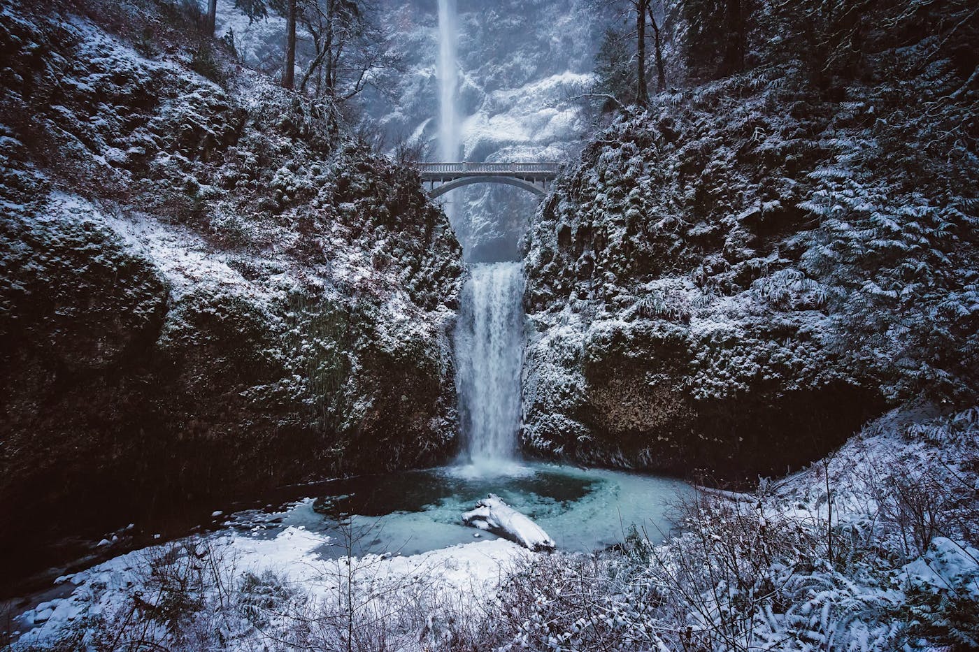 Scenic winter scene of snow-covered Multnomah Falls with a bridge in Oregon.