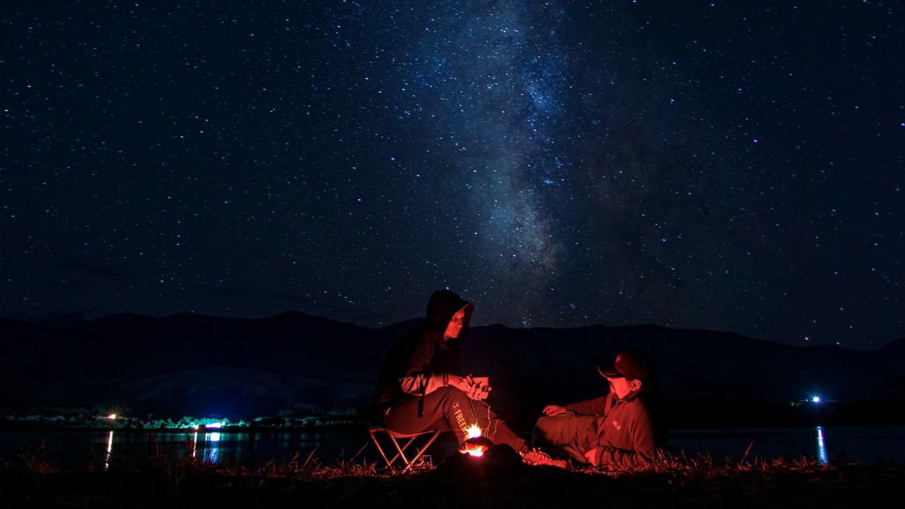 Campfire glowing under a star-filled night sky in Central Oregon's high desert