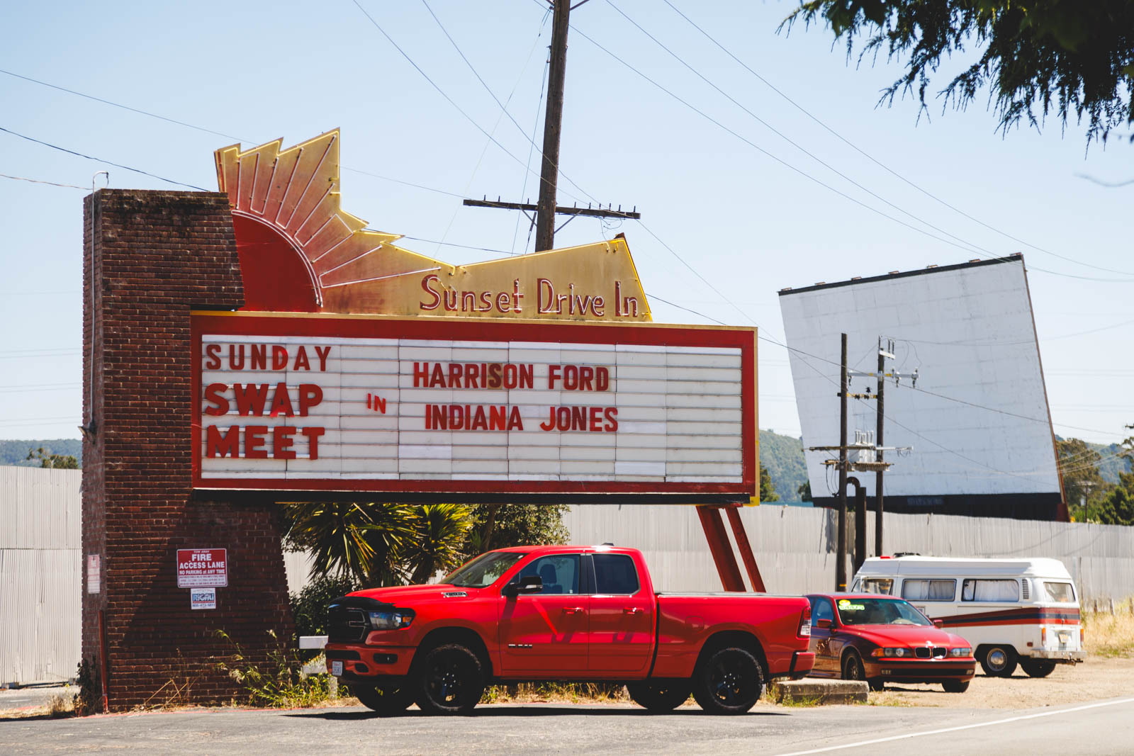 Retro drive-in movie theater marquee sign lit up at sunset