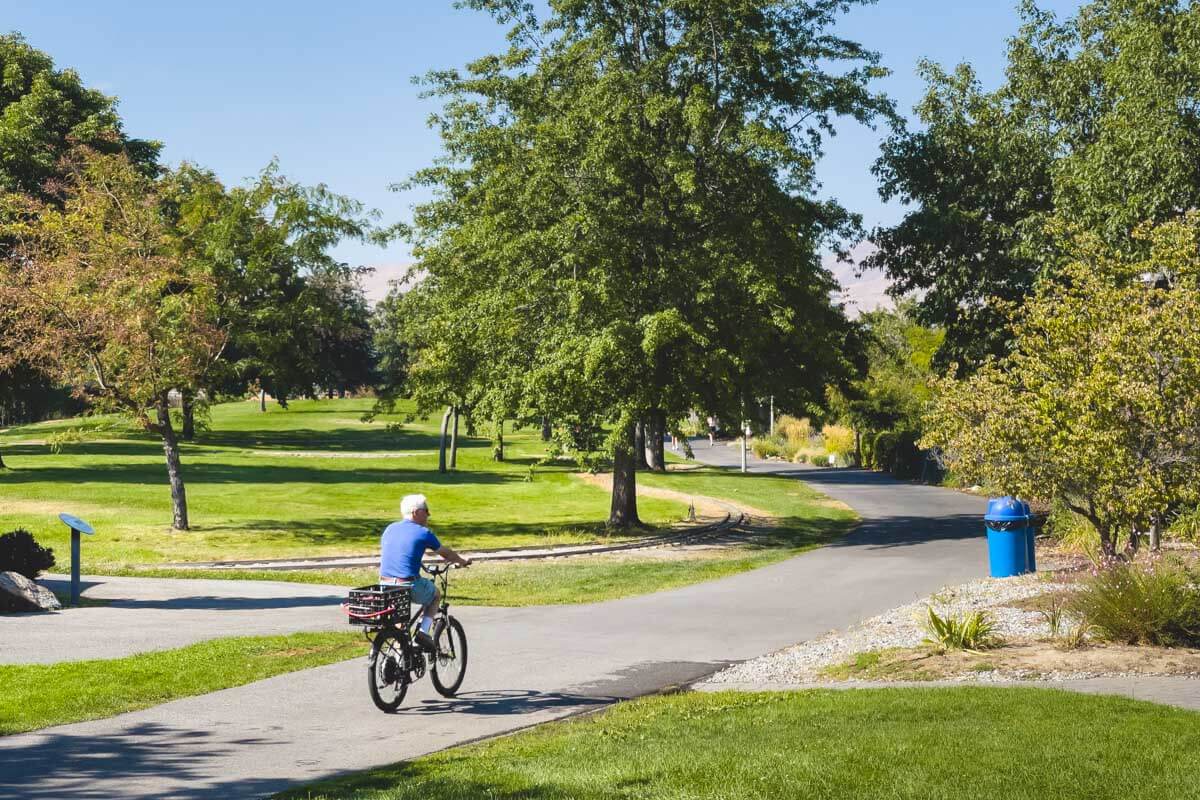 A cyclist riding a paved trail in Washington state